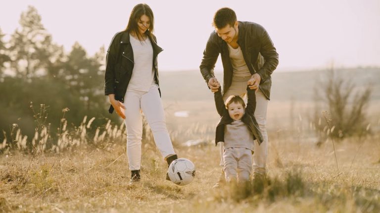 A joyful family playing soccer together in a sunlit field, showcasing love and togetherness.